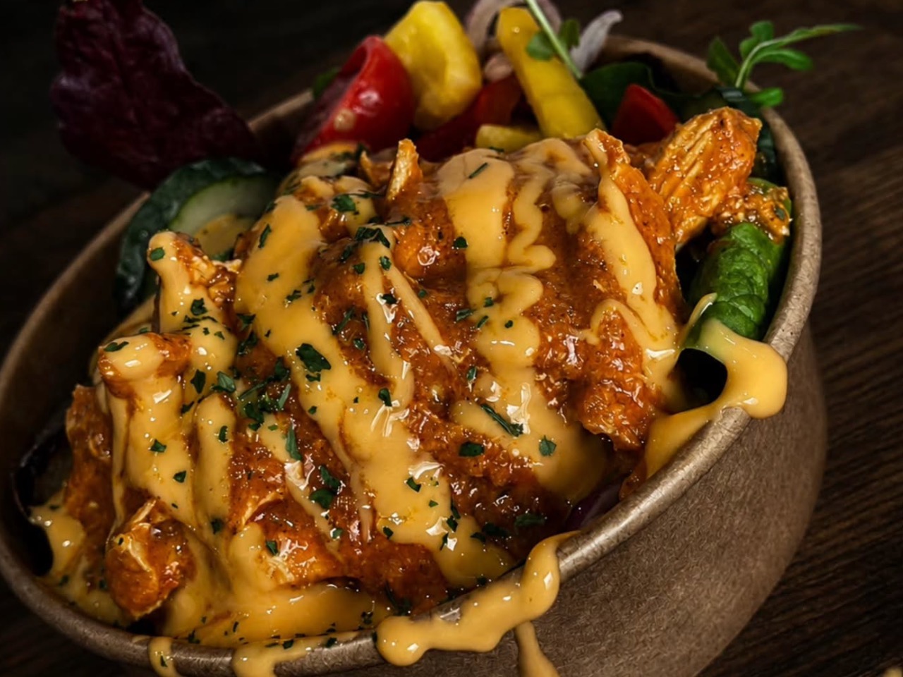 A hot bowl of tender chicken smothered in rich, drizzled curry sauce and fresh garnishes for workplace canteen catering.