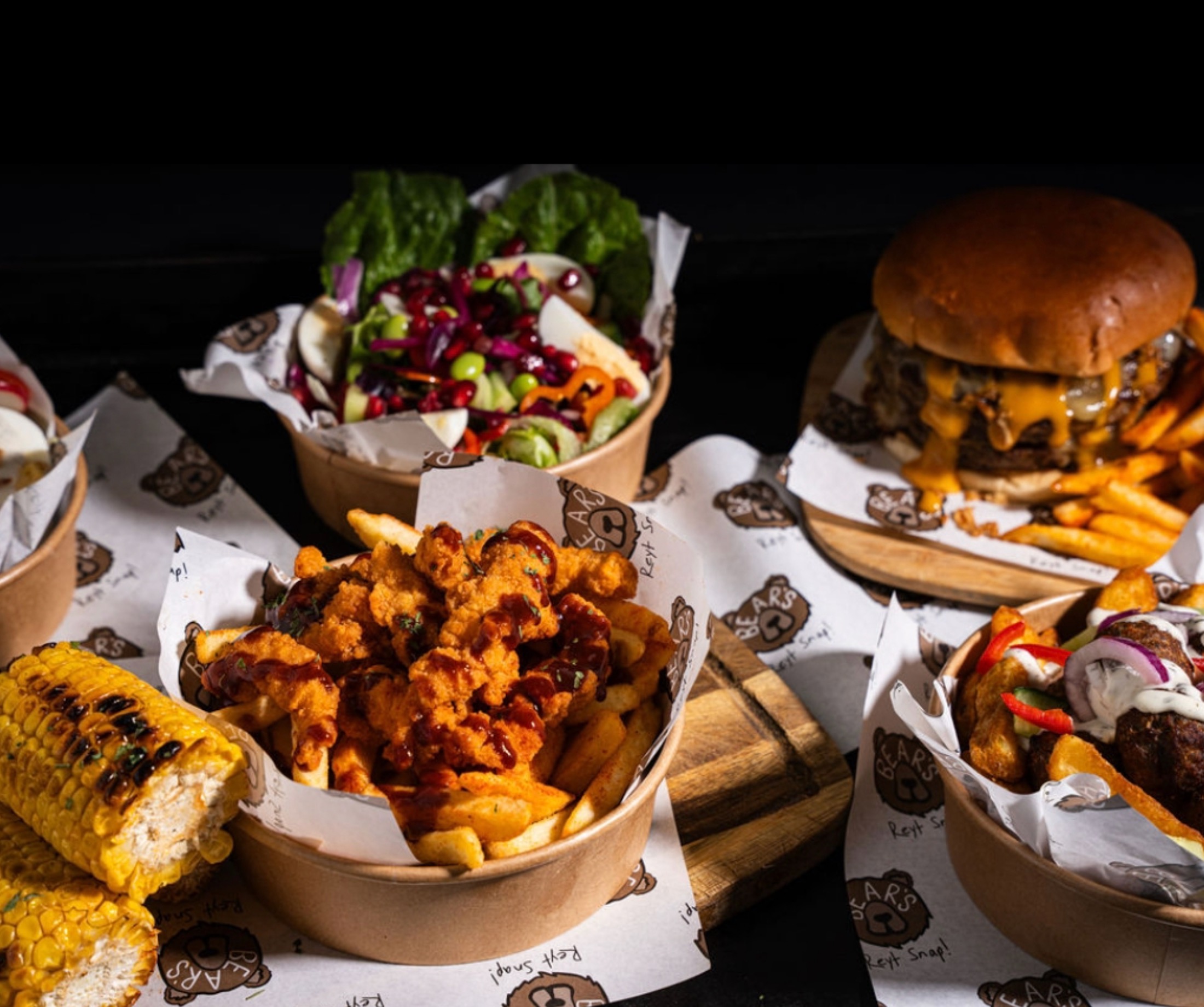 A diverse street food spread featuring customisable salad bases, grilled proteins and fresh sides suitable for mass workplace canteen catering.
